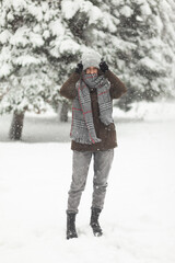 Fototapeta na wymiar Portrait of attractive woman in warm clothes in winter snowy weather outdoors