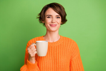 Photo of relaxed happy young pretty woman hold coffee cup weekend rest isolated on green color...