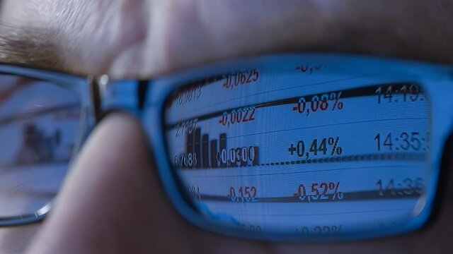 In the glasses of a trader which trading on the exchange, on a Forex is a chart with  indicators is reflected. Macro. Close Up