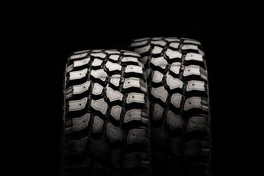 Two Mud Tires On A Black Background, Powerful Dirt Tread For Off-road Driving