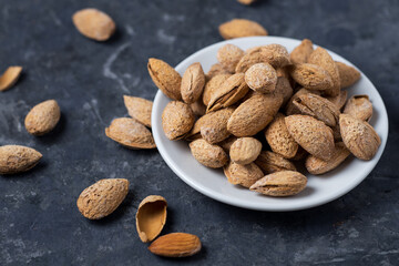Roasted salted almonds on a dark table