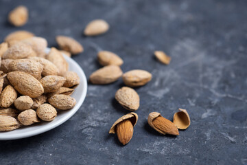 Roasted salted almonds on a dark table