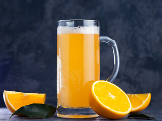 Fruit juicy summer beer in a glass mug with orange . Radler beer