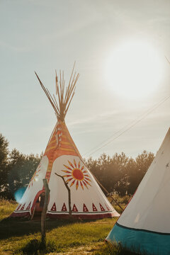 Tipi house in the forest against the background of trees, camping, village in the forest, camping. Indian teepee house at sunset.