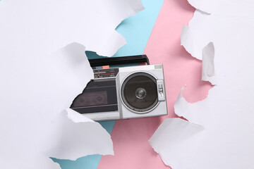 Retro boombox audio player on blue-pink background with torn paper. Concept art. Pastel color trend. Creative layout. Minimalism. Top view