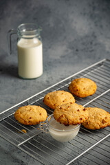 galletas con chispas de chocolate sobre parrilla acompañadas de vaso de leche