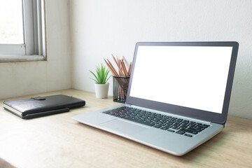 Fototapeta premium Laptop computer with white blank screen on wood desk. Workspace, workplace, desktop office concept.