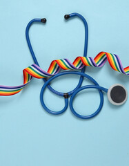 Rainbow lgbt ribbon and stethoscope on blue background