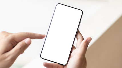 Hand holding and using smartphone with white blank on screen.