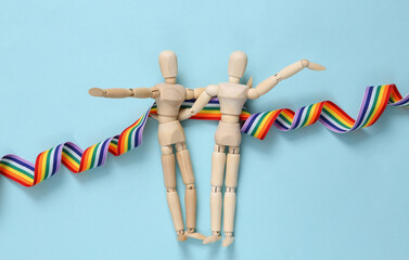 Lgbt community, relationships. Two puppets of the same sex hugging on a blue background with a...