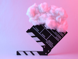 Movie clapperboard with floating fluffy cloud in pink blue neon light. Concept art. Minimalistic...