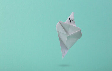 Soaring origami ghost on a blue background. Creative halloween concept