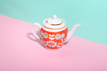 Ceramic retro teapot on blue-pink background. Minimalism. Trendy shadow. Creative layout