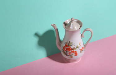 Retro teapot on blue-pink background. Minimalism. Trendy shadow. Creative layout.