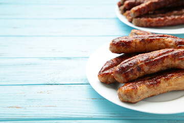 Roasted sausage on plate on blue background with copy space