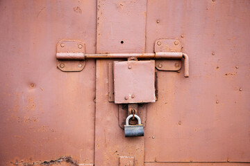 Old lock of the metal door.  Rusty old metal texture with remnants of the paint. Grungy background for any design. 
