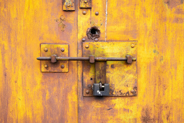 Old lock of the metal door.  Rusty old metal texture with remnants of the paint. Grungy background for any design. 
