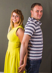 Happy young couple holding hands together.