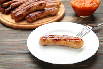 Grilled sausage on plate on brown background