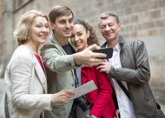 tourists taking selfie on old street of European city