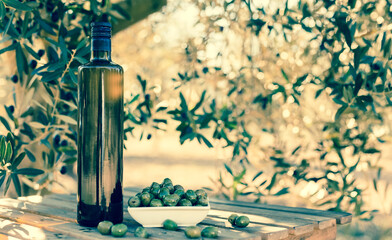 green olives and oil on table in olive grove