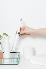 Hand with electric tooth brush on a white background. Oral care concept.