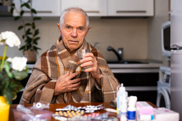 old man with many medical pills and capsules in hands