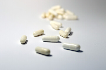 Fototapeta na wymiar pills and capsules spilled on white background