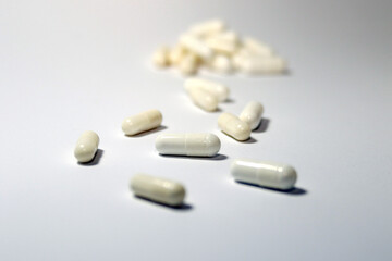 pills and capsules spilled on white background