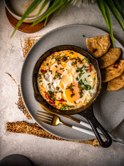 huevos mediterraneos en sarten sobre bandeja