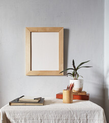 Wooden frame mockup. Scandinavian minimal design. Flowerpot on a pile of books on an old wooden...