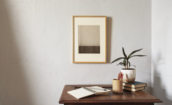 Wooden frames mockup. Dry decorative artichokes in a vase on an old wooden desk. Composition on a white wall background