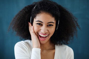 Close-up of young woman with headphones indoors at home, listening to music.