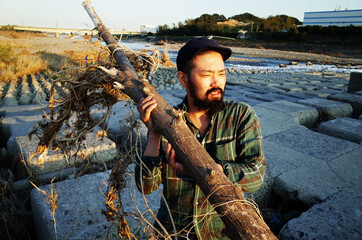 流木を持ち上げるワイルドな男