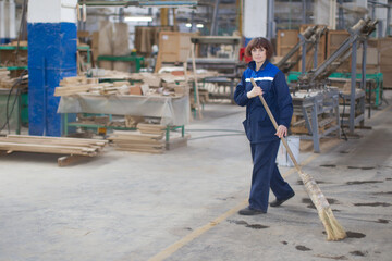 The cleaner in the furniture shop.Cleaning woman at the factory