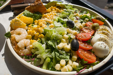 Classic cobb salad with shrimp, tomatoes, eggs, avocado and cheese.