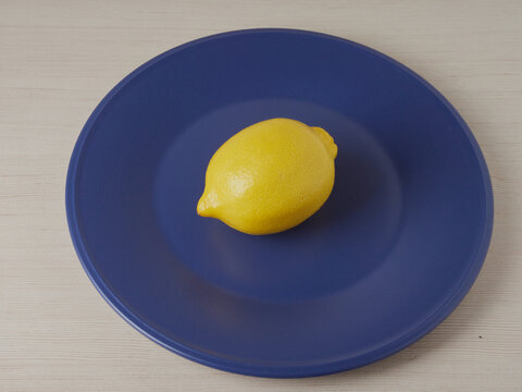 Yellow Lemon On A Blue Glass Plate.