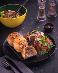 East Asian Dish Middle Eastern Cuisine Asian Baked Samsa with meat served with salad on black table.Concept for menu for restaurant.