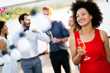 Group of happy friends drinking champagne and celebrating New Year