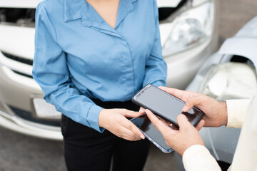 Two Drivers using a smartphone to exchange phone numbers and social media after a car accident. Concept of claim insurance for a car accident online after send photo and evidence to insurance company