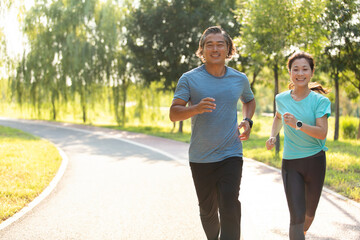 Happy mature couple running in park