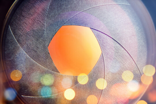 The camera lens on the background of the fiery city lights. Concept on the topic of news, media, information. Camera Lens background.