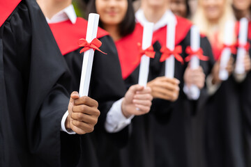 Hands of multiracial group of graduators showing diplomas