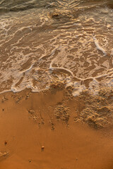 Waves by the rocky seashore with sandy beach at the Egypt resort. Top view background with copy space