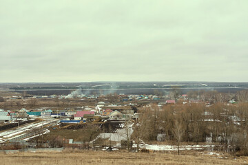 typical suburb near Moscow. Cottages, fields and forest belt aerial view. Early spring