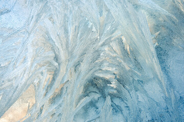 frosty patterns on the window glass closeup. natural textures and backgrounds. ice patterns on...