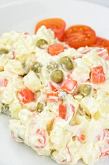 Homemade russian salad on white plate