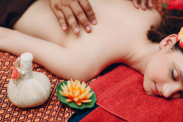 Obraz na płótnie Canvas Thai man making classical thai massage procedure to young woman at beauty spa