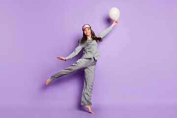 Fototapeta na wymiar Full length body size photo of girl in grey pajama sleeping mask jumping keeping balloon isolated pastel purple color background