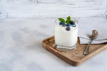 White yogurt in glass with fresh berries and mint. Healthy food, snack or breakfast